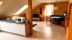 a kitchen and living room with a microwave and a table at Ferienwohnung Brenner in Bruck an der Mur