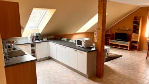a kitchen with white cabinets and a large window at Ferienwohnung Brenner in Bruck an der Mur