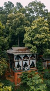 Mae Onにあるทโล้ โฮมสเตย์ เชียงใหม่ | Taloh Homestay Chiangmaiの木々の森の中の家