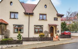 a white house with a red car parked in front of it at 3 Bedroom Stunning Home In Jena in Jena