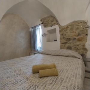 een slaapkamer met een groot bed en een stenen muur bij Il Giardino di Gio' in Imperia
