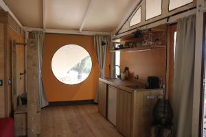 a kitchen with a round window in a room at Glamping La Ghianda in Elmo