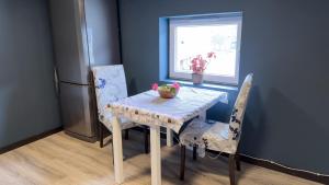 een tafel en stoelen in een keuken met een raam bij Puntsnes Apartmen in Hjelmeland