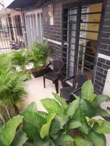 a patio with chairs and plants in front of a house at La Lunar un espacio ideal para trabajar y conocer Medellín in Medellín