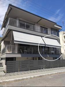 a building with a white awning on the side of it at Kyriakos Apartment in Nea Potidaea