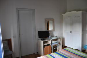 a bedroom with a bed and a desk with a television at Villa Acquafredda in Orvieto