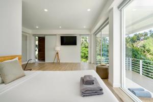 una camera da letto con un grande letto bianco e una grande finestra di PRIVATE POOL VILLA I Sea & Mountain Views - Privacy a Chaweng Noi Beach
