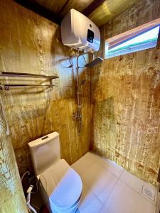 niewielka łazienka z toaletą i lampką w obiekcie Glamping Omah Kayu at Watu Paris Jogja w mieście Girijati