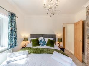 a bedroom with a large bed with green pillows at Glanllyn in Betws-y-coed