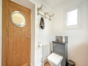ein Badezimmer mit einem WC und einer Holztür in der Unterkunft Glanllyn in Betws-y-coed