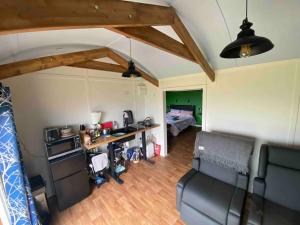 uma sala de estar com um sofá e uma cama em Hafan y Mynydd - Accessible double shepherd hut em Machynlleth