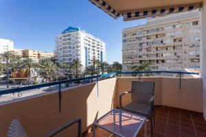 balkon z 2 krzesłami i stołem w budynku w obiekcie Apartamento Marbella Playa Av Nabeul w Marbelli