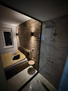 a bedroom with a bed and a brick wall at Apartman North in Mladenovac