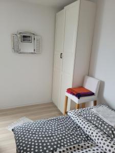 sypialnia z łóżkiem, krzesłem i kuchenką mikrofalową w obiekcie Kawalerka Gdynia w mieście Gdynia