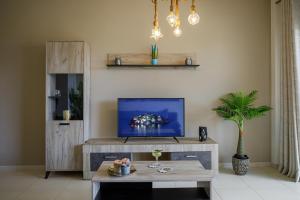 a living room with a tv and a table at Savvas Apartment in Tolo