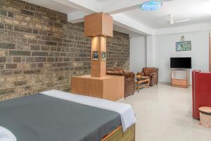 a room with a bed and a brick wall at Master room pvt garden by Vanasthali in Kasauli