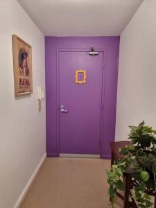 a purple door in a room with a plant at Little Monica Apartment- Spacious, Affordable & Central in Perth