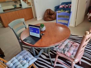 a table with a laptop sitting on top of it at Little Monica Apartment- Spacious, Affordable & Central in Perth +7 photos
