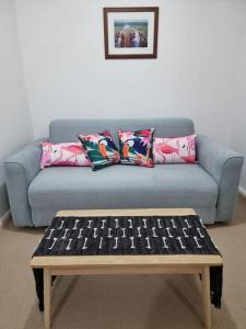 - un canapé bleu avec des oreillers et une table basse dans l'établissement Little Monica Apartment- Spacious, Affordable & Central, à Perth