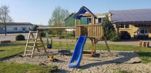 a playground with a blue slide and a ladder at Ferienwohnung Hof Konietzke in Thale
