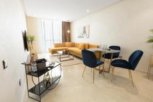 a living room with a couch and a table and chairs at ZEN Suites Hotel Massira in Casablanca