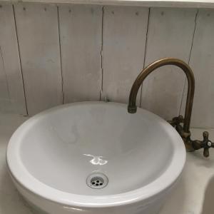 La salle de bains est pourvue d'un lavabo blanc et d'un robinet. dans l'établissement Fiordiloto, à Monsampolo del Tronto