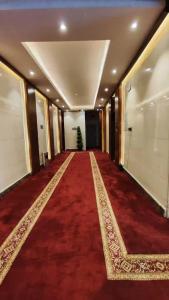 un pasillo con una alfombra roja y un largo pasillo con un árbol de Navidad en الماسم للأجنحة المخدومة- الملك فهد, en Riad