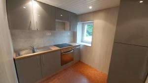 eine kleine Küche mit Spüle und Kühlschrank in der Unterkunft Gite St Pol de Léon 4 chambres, draps fournis in Saint-Pol-de-Léon