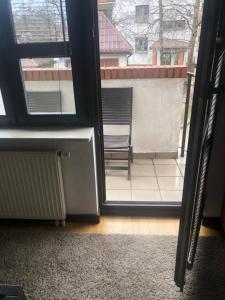uma porta aberta para uma varanda com uma cadeira no exterior em Apartament Odkryta 36a em Varsóvia