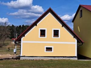 Horní Stropnice的住宿－RYBÁŘSKÁ CHALUPA，黄色的房屋,有红色的屋顶