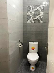 ein Badezimmer mit Toilette und einem Gemälde an der Wand in der Unterkunft ბინა131 in Tbilisi City + 7 Fotos