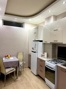a kitchen with a table and a white stove top oven at ბინა131 in Tbilisi City