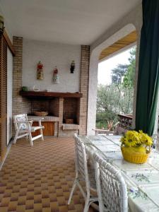 un patio con mesa, sillas y chimenea en Affittacamere Villa Sofia con uso cucina e ampio giardino, en Calcinelli