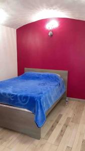 Un dormitorio con una cama con una sábana azul. en Loft moderne au cœur de l’Auvergne, en Thiers