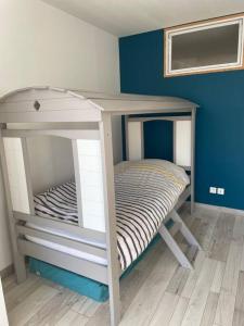 een stapelbed in een kamer met een blauwe muur bij Loft moderne au cœur de l’Auvergne in Thiers