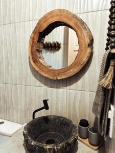 a bathroom with a stone sink and a mirror at CASA MUNDI in Caraíva