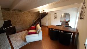 a living room with a table and a white chair at Gite St Pol de Léon 4 chambres, draps fournis in Saint-Pol-de-Léon