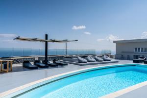 a swimming pool on the roof of a building with a view at Abrazo Villas in Imerovigli