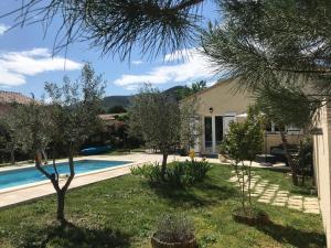 ein Haus mit Pool und Bäumen im Hof in der Unterkunft Coeurs fidèles in Vallon-Pont-dʼArc