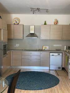 a kitchen with wooden cabinets and a rug at Belleview Heights in Limassol