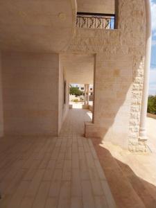 una habitación vacía con una pared de ladrillo y una puerta abierta en Four session apartments jarash, en Jerash