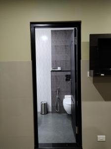 La salle de bains est pourvue de toilettes et d'une télévision. dans l'établissement Kottavathil Hotel, à Tripunittura