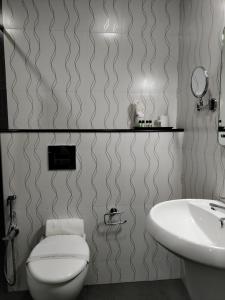 a bathroom with a toilet and a sink at Kottavathil Hotel in Tripunnittara