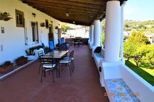 une terrasse avec des chaises et des tables dans une maison dans l'établissement Villa la Milanina, à Lipari