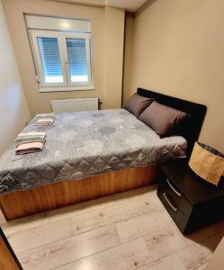 a bedroom with a large bed with a window at Apartman Rojal Vranje in Vranje