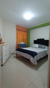 a bedroom with a bed and a dresser at Renacer apartamentos in Tacna