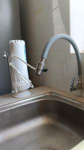 a kitchen sink with a faucet and a roll of paper towels at Renacer apartamentos in Tacna