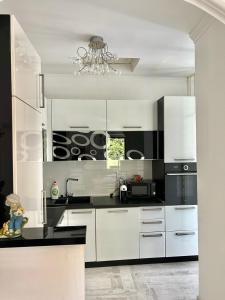 uma cozinha com armários brancos e electrodomésticos pretos em Apartment Kiki em Kotor