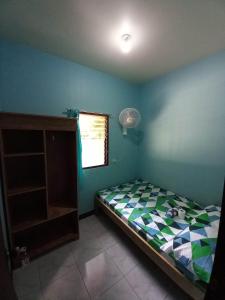 a small bedroom with a bed and a window at CBHaus in El Nido
