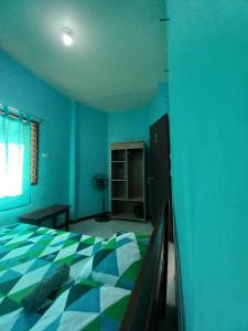 a blue bedroom with a bed with a checkered blanket at CBHaus in El Nido